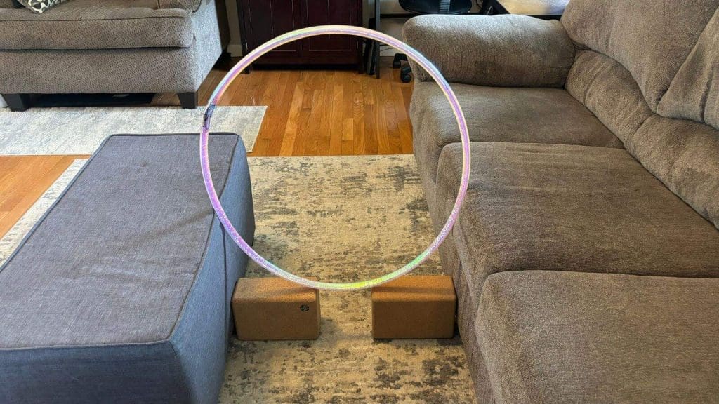 Hula hoop used as a beginner dog agility hoop held in place by furniture